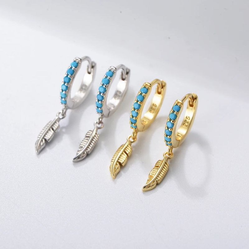 Three pairs of hoop earrings with feather designs on a light gray background