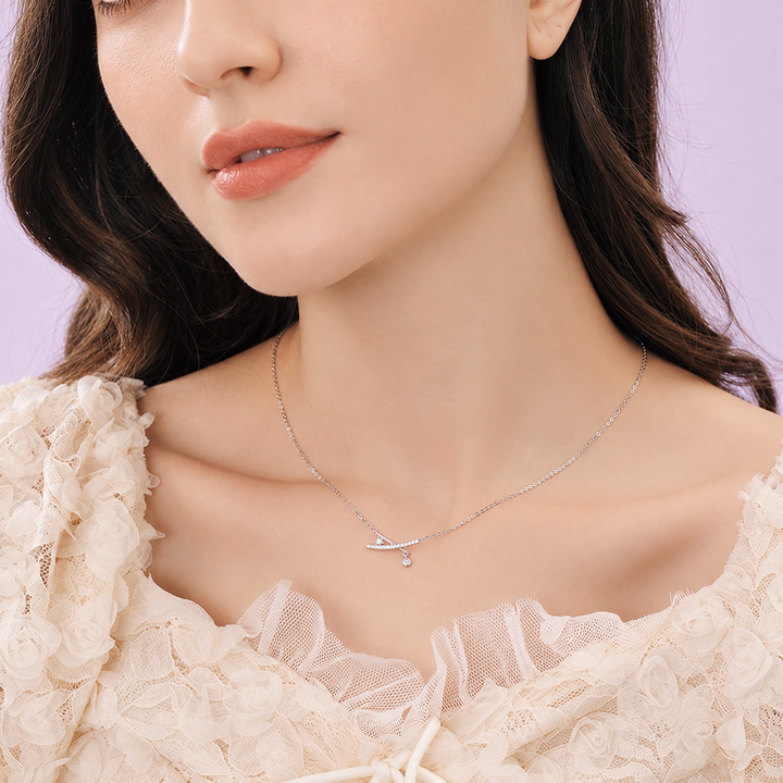 X-Cross Studded Pendant Necklace worn on a model with soft lavender studio background