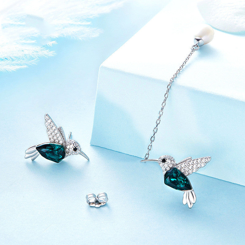 Hummingbird asymmetrical earrings showing the mismatched hummingbird designs, chain, pearl, and earring back