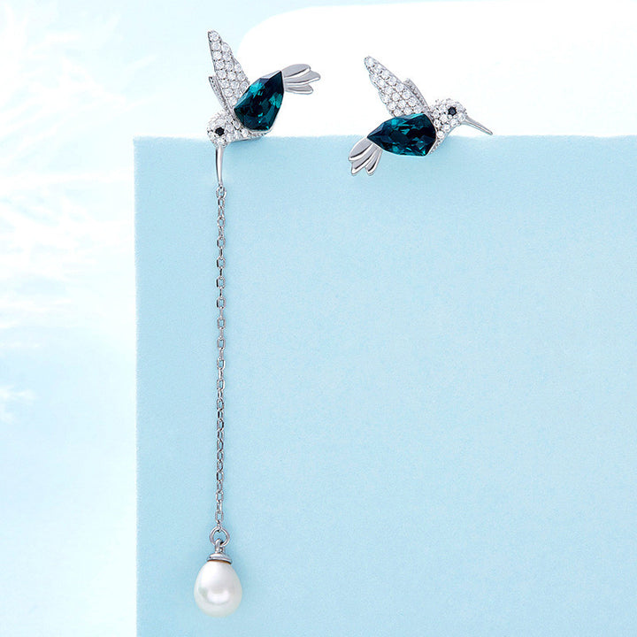 Hummingbird asymmetrical earrings featuring blue hummingbird designs with a long pearl drop